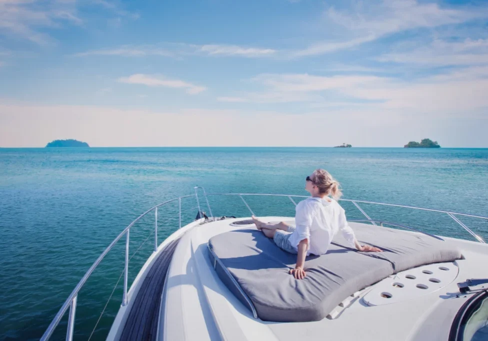 Woman relaxing on yacht in blue ocean.